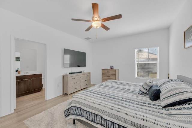 bedroom with ceiling fan, light wood finished floors, visible vents, and ensuite bathroom