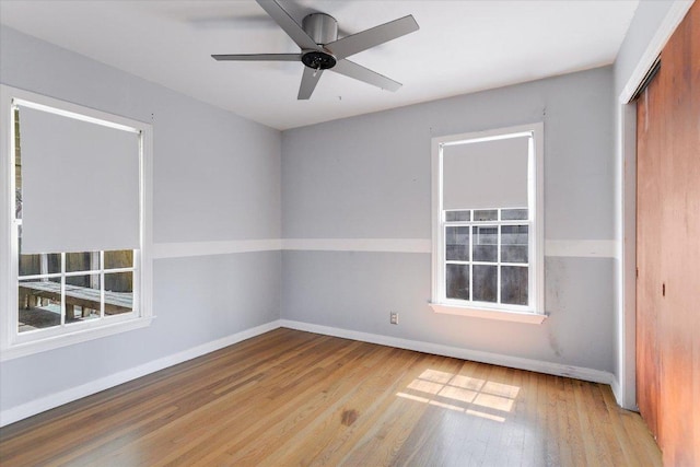 empty room with baseboards, a ceiling fan, and wood finished floors