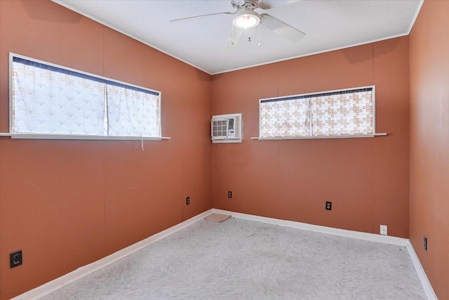 empty room featuring a wall unit AC, crown molding, baseboards, and a ceiling fan