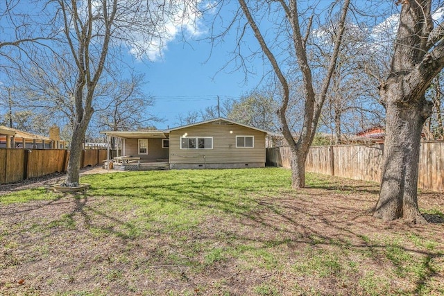 back of property featuring crawl space, a fenced backyard, and a lawn