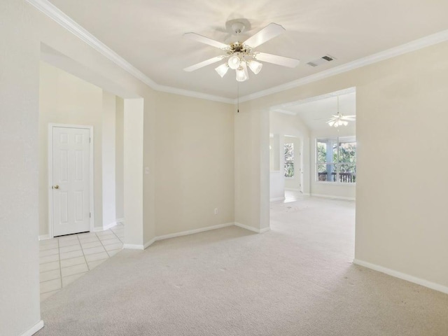 carpeted spare room featuring baseboards, visible vents, a ceiling fan, and ornamental molding