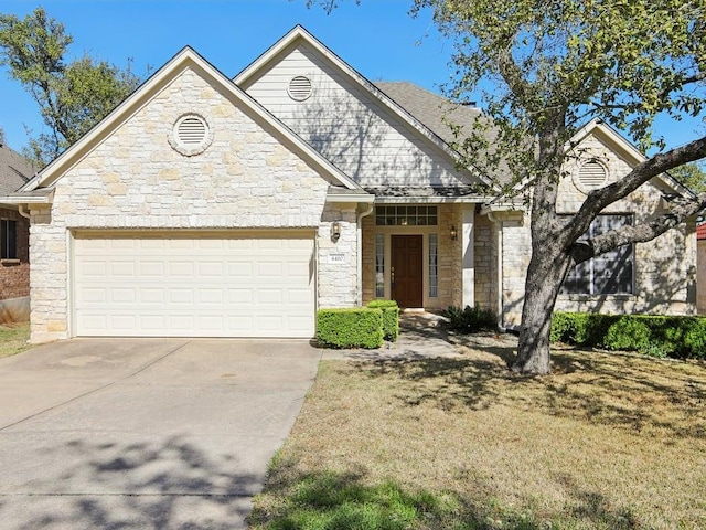 view of front facade featuring stone siding, driveway, and an attached garage