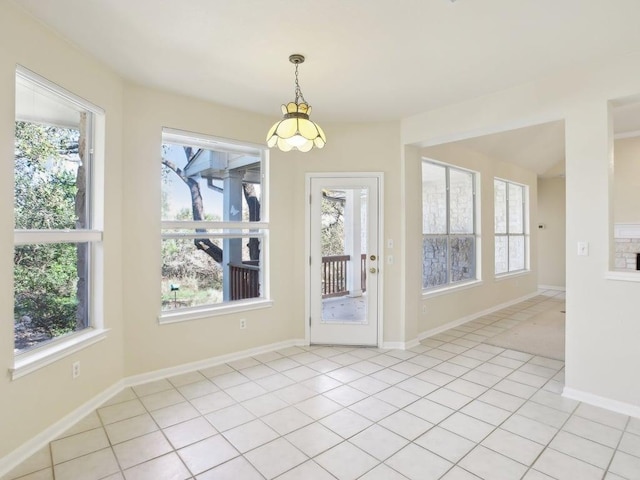 unfurnished dining area featuring light tile patterned flooring and baseboards