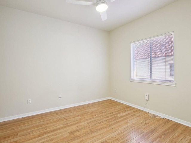 spare room with baseboards, ceiling fan, and light wood-style floors