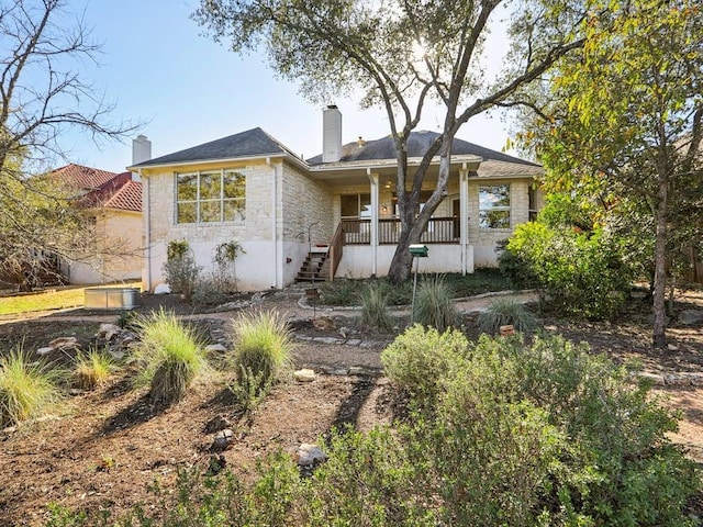 single story home with covered porch and a chimney