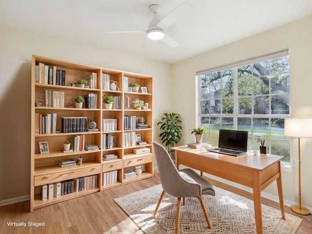 office space featuring a ceiling fan, light wood-style flooring, and baseboards