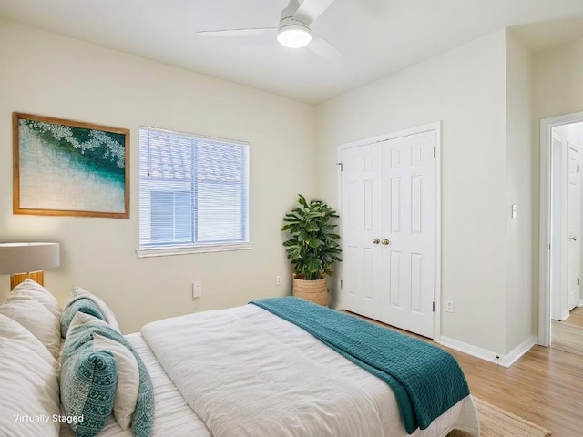 bedroom with baseboards, a closet, a ceiling fan, and light wood-style floors