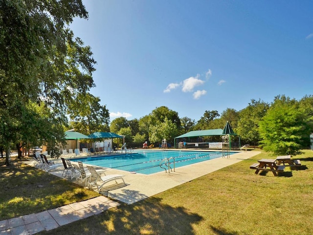 community pool with a patio area and a lawn