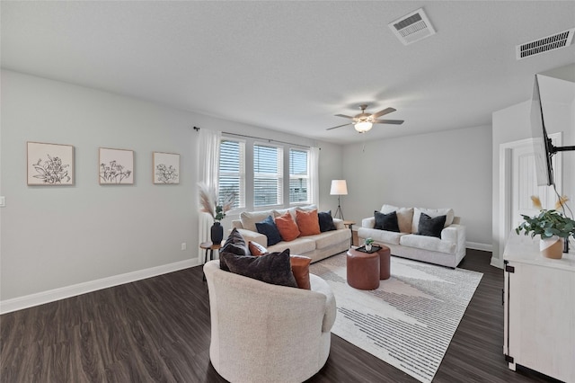 living room featuring dark wood-style floors, baseboards, and visible vents