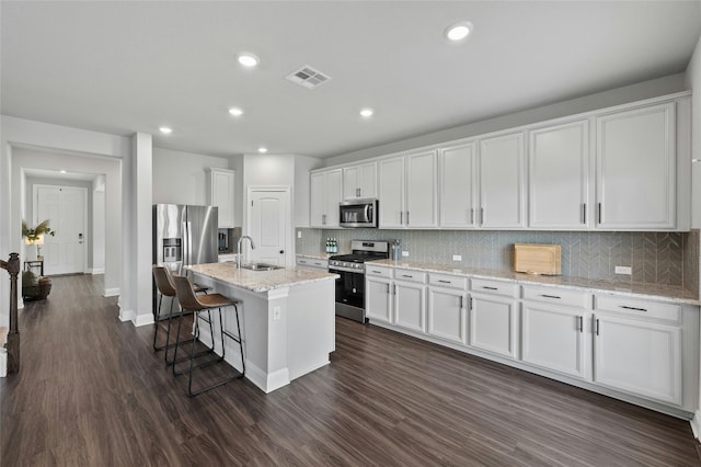 kitchen with visible vents, dark wood finished floors, appliances with stainless steel finishes, white cabinetry, and a sink