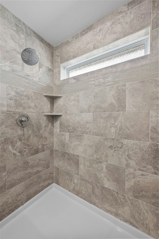 full bath featuring tiled shower