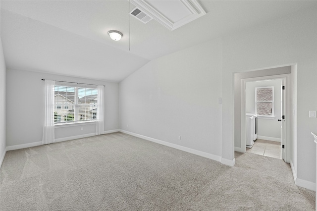 carpeted empty room with lofted ceiling, attic access, visible vents, and baseboards