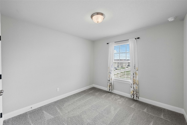 unfurnished room with carpet and baseboards