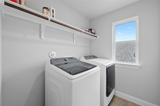 laundry room featuring light tile patterned floors, laundry area, separate washer and dryer, and baseboards