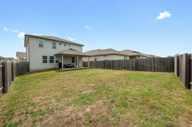 back of house with a yard, a patio area, and a fenced backyard