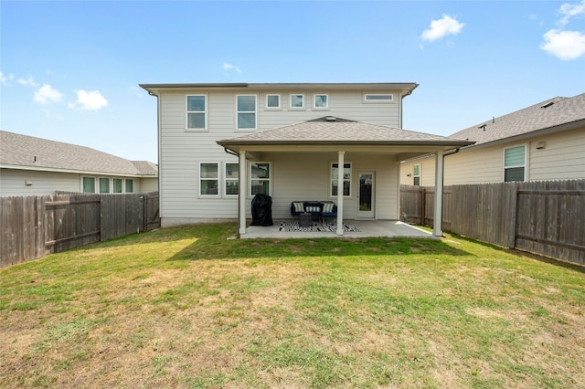 rear view of house with a fenced backyard, a yard, and a patio