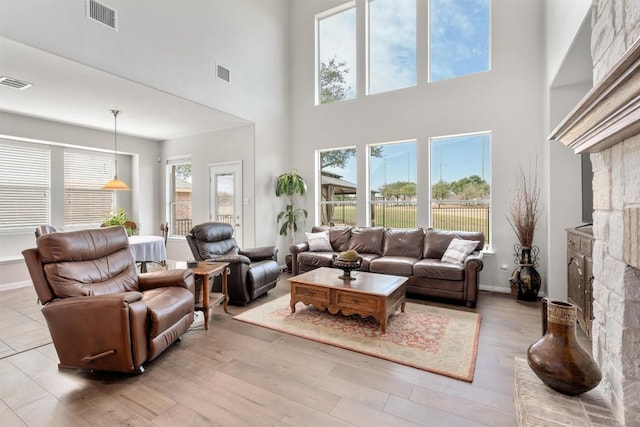 living area with a fireplace, wood finished floors, and visible vents