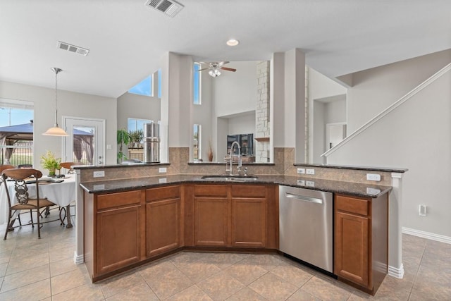 kitchen featuring stainless steel dishwasher, brown cabinetry, a sink, and visible vents