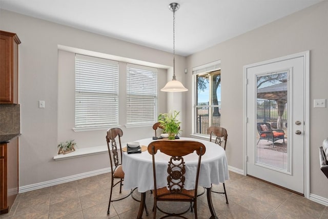 tiled dining area featuring baseboards