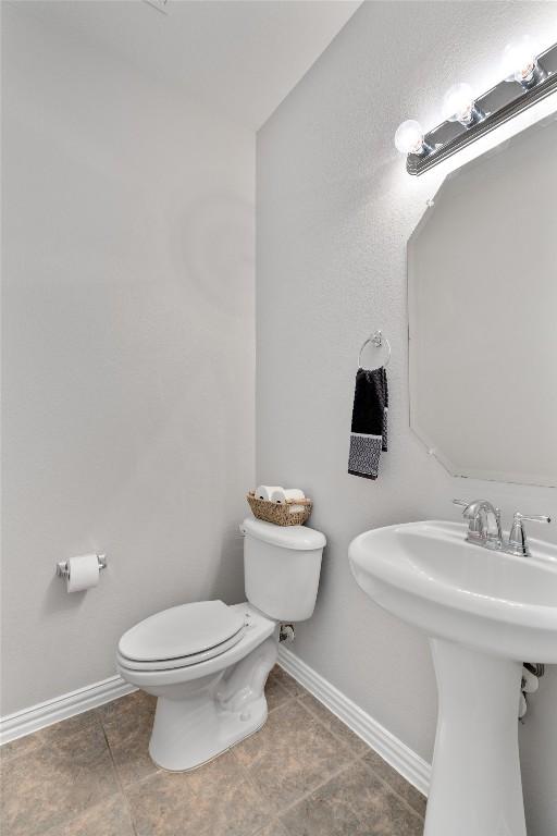 bathroom featuring baseboards, toilet, and tile patterned floors