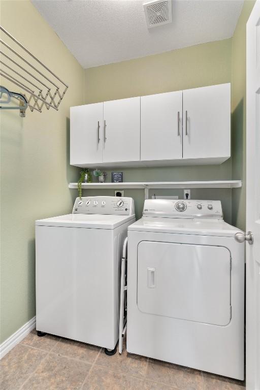 washroom with visible vents, independent washer and dryer, cabinet space, and baseboards