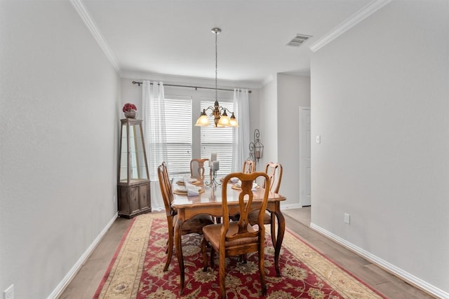 dining area with baseboards, light wood-type flooring, visible vents, and crown molding