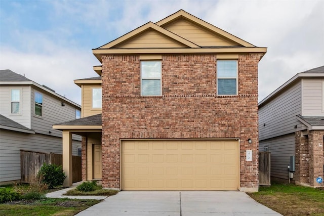 traditional home with concrete driveway, brick siding, fence, and an attached garage