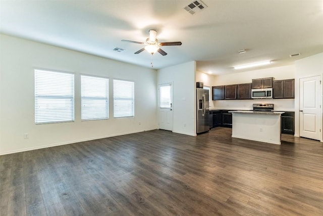 kitchen featuring stainless steel appliances, dark wood-style flooring, visible vents, open floor plan, and a center island