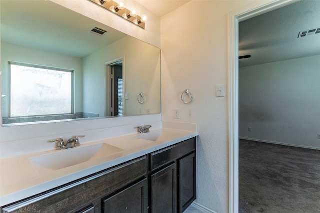 bathroom with double vanity, a sink, and visible vents