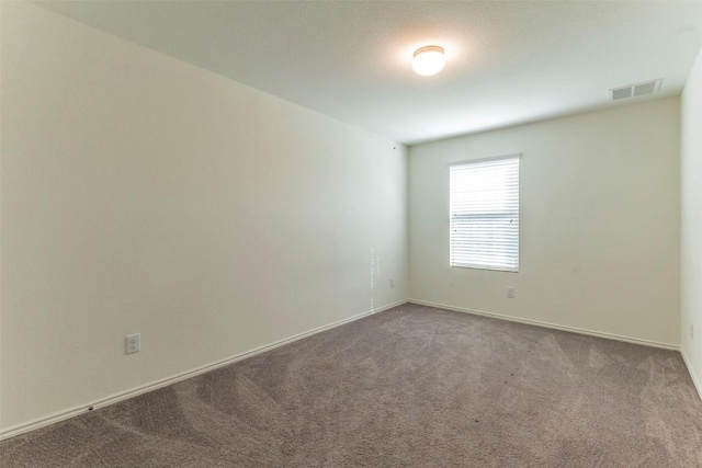 unfurnished room featuring baseboards, visible vents, and carpet flooring