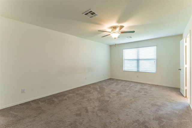 carpeted empty room featuring visible vents, ceiling fan, and baseboards