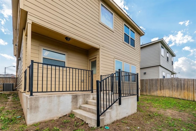 view of home's exterior with fence and cooling unit