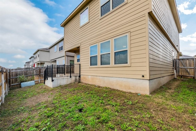 back of house featuring a lawn and a fenced backyard