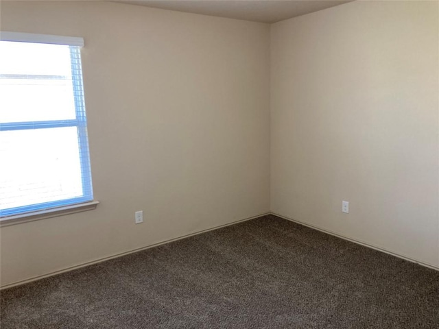 empty room with plenty of natural light and dark carpet