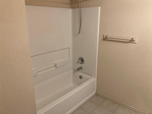 bathroom featuring baseboards, a textured wall, tub / shower combination, and tile patterned floors