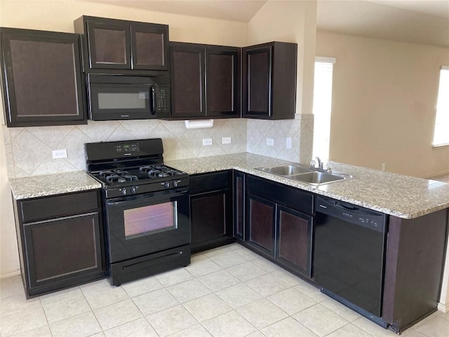 kitchen featuring backsplash, a sink, light stone countertops, a peninsula, and black appliances