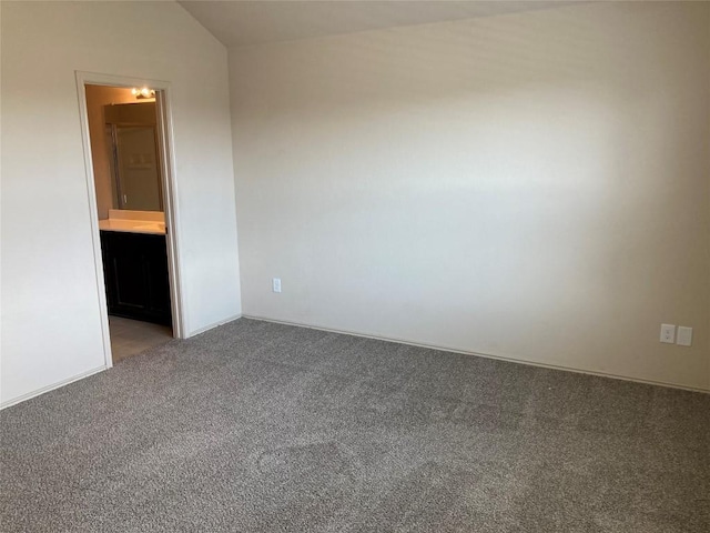 carpeted empty room with vaulted ceiling