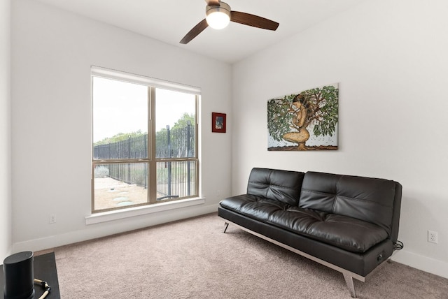 living area featuring carpet floors, ceiling fan, and baseboards