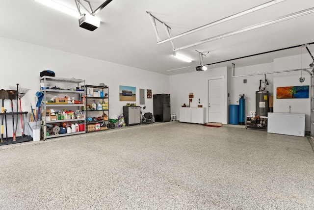 garage with freestanding refrigerator, electric panel, electric water heater, and a garage door opener