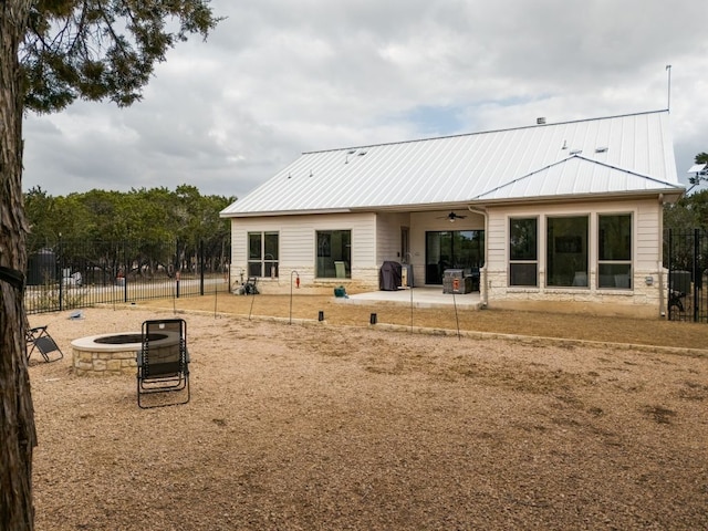 rear view of house with ceiling fan, metal roof, a patio area, and fence