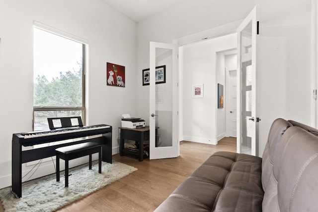 sitting room with french doors, baseboards, and wood finished floors