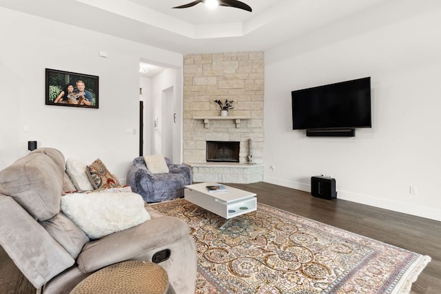 living room with ceiling fan, baseboards, and wood finished floors