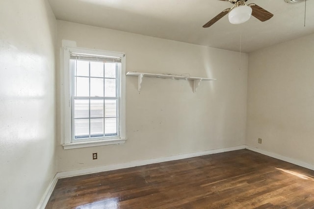 spare room featuring ceiling fan, baseboards, and dark wood finished floors