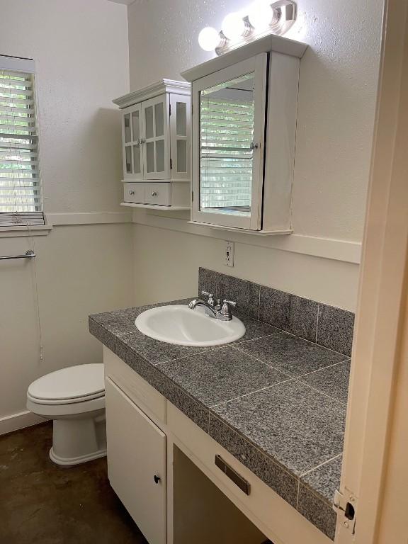 half bathroom featuring toilet and vanity