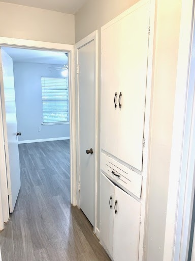 hall featuring baseboards and wood finished floors