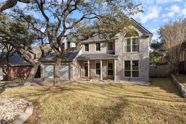 traditional-style home featuring concrete driveway, a front lawn, an attached garage, and fence