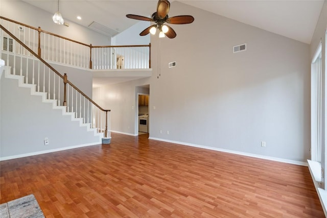 unfurnished living room featuring light wood-type flooring, visible vents, stairway, and baseboards