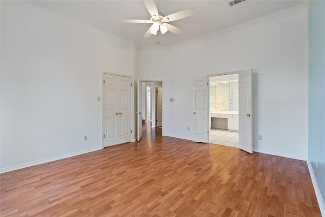 unfurnished bedroom with light wood-style floors, visible vents, crown molding, and baseboards