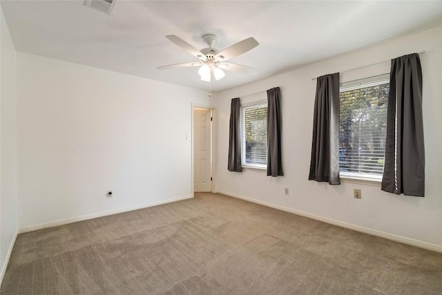 spare room featuring baseboards, visible vents, ceiling fan, and carpet flooring