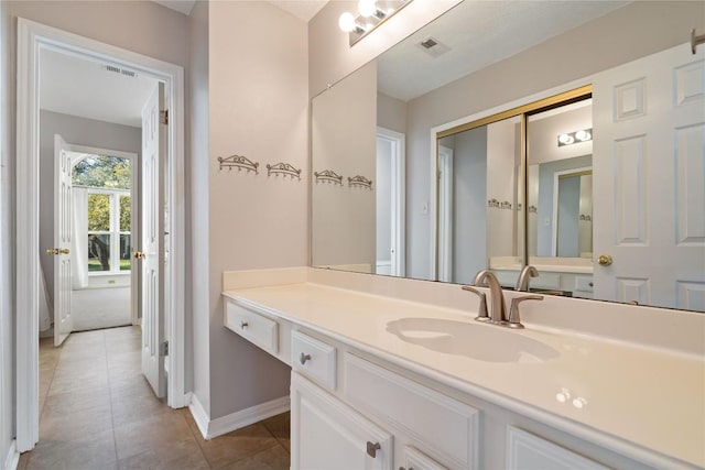 bathroom featuring tile patterned flooring, visible vents, baseboards, and vanity